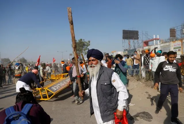 A farmer brandishes a stick during a protest against the newly passed farm bills at Singhu border near Delhi, India, November 27, 2020. (Photo by Danish Siddiqui/Reuters)