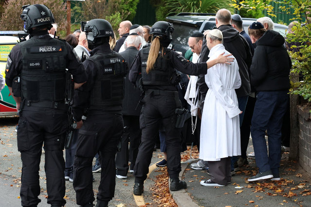 People gather near the scene, after a report of an incident in which a car was driven at pedestrians and a stabbing attack, near a synagogue in north Manchester, Britain, on October 2, 2025. (Photo by Phil Noble/Reuters)