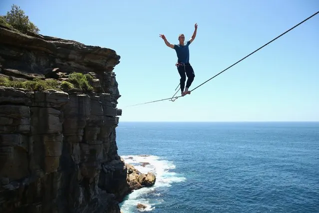 Antek Marciniec walks along a slackline as he highlines between two cliffs at Diamond Bay on December 21, 2014 in Sydney, Australia. (Photo by Cameron Spencer/Getty Images)
