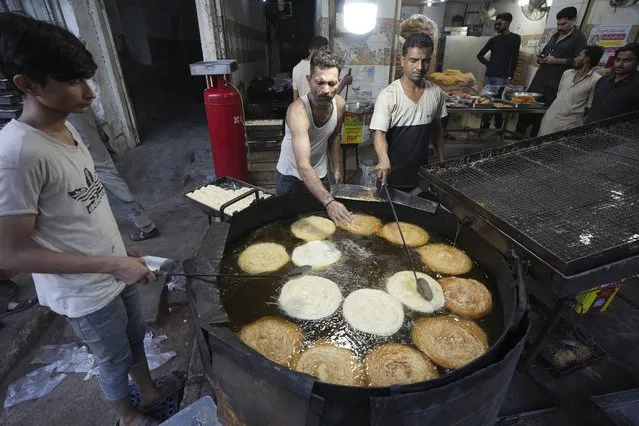 Workers fry vermicelli, a special delicacy prepared for the upcoming Muslim fasting month of Ramadan, in Karachi, Pakistan, Tuesday, March 21, 2023. Muslims across the world will be observing the Ramadan, when they refrain from eating, drinking and smoking from dawn to dusk. Ramadan is expected to officially begin Thursday or Friday in Pakistan, though the timing depends on the alignment of the moon. (Photo by Fareed Khan/AP Photo)