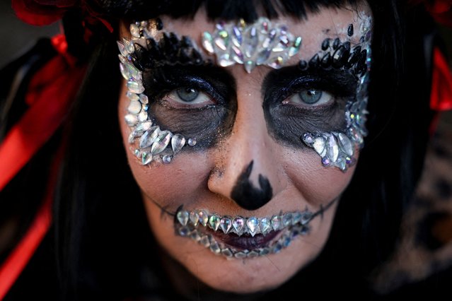 Elaine Duffy looks on with her face painted as revellers take part in the annual Halloween Derry carnival parade in Londonderry, Northern Ireland, on October 31, 2025. (Photo by Cathal McNaughton/Reuters)
