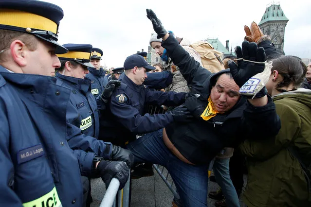 Protestors are pushed by Royal Canadian Mounted Police (RCMP) officers while trying to cross a police barricade during a demonstration against the proposed Kinder Morgan pipeline on Parliament Hill in Ottawa, Ontario, Canada, October 24, 2016. (Photo by Chris Wattie/Reuters)