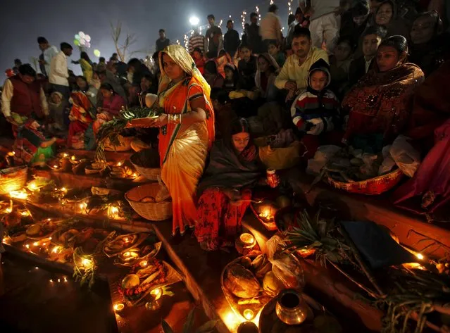 Hindu devotees gather on the banks of a lake to offer prayers to the rising sun during the Hindu religious festival of Chatt Puja in Chandigarh, India, November 18, 2015. (Photo by Ajay Verma/Reuters)