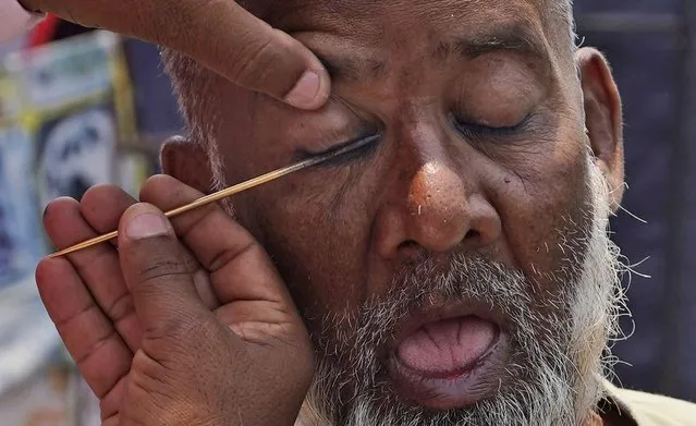 A Muslim gets Surma or collyrium for his eye before offering last Friday prayers of Ramadan at Mecca Masjid in Hyderabad, India, Friday, April 21, 2023. Surma or collyrium is popular among Muslims, especially on Fridays and in the holy month of Ramadan, a period of intense prayer, self-discipline, dawn-to-dusk fasting and nightly feasts. (Photo by Mahesh Kumar A./AP Photo)