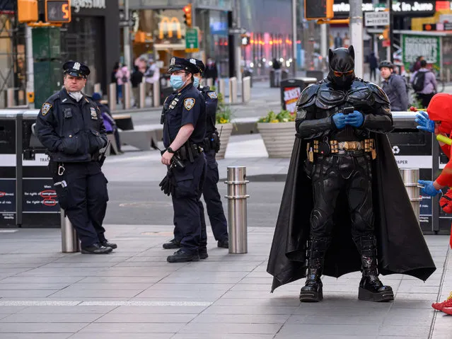 NYPD officers and Batman stand in Times Square during the coronavirus pandemic on May 20, 2020 in New York City. COVID-19 has spread to most countries around the world, claiming over 329,000 lives with over 5 million infections reported. (Photo by Noam Galai/Getty Images)