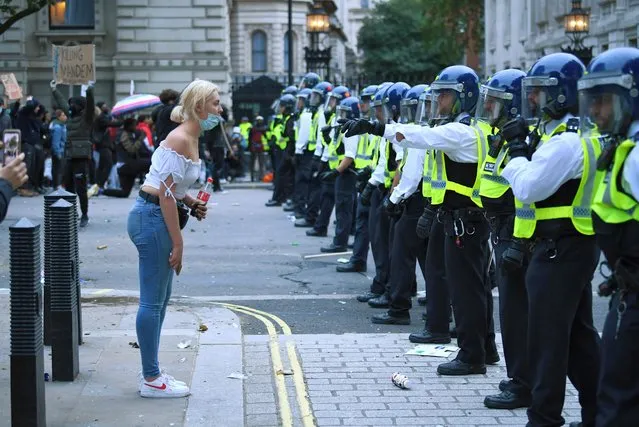 A woman stands in front of police officers during a Black Lives Matter protest in London, following the death of George Floyd who died in police custody in Minneapolis, London, Britain, June 7, 2020. (Photo by Dylan Martinez/Reuters)
