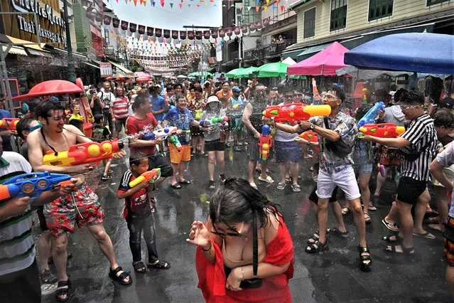 People take part in mass water fights during the first day of Songkran, or Thai New Year, on Khao San Road in Bangkok on April 13, 2023. (Photo by Lillian Suwanrumpha/AFP Phoot)