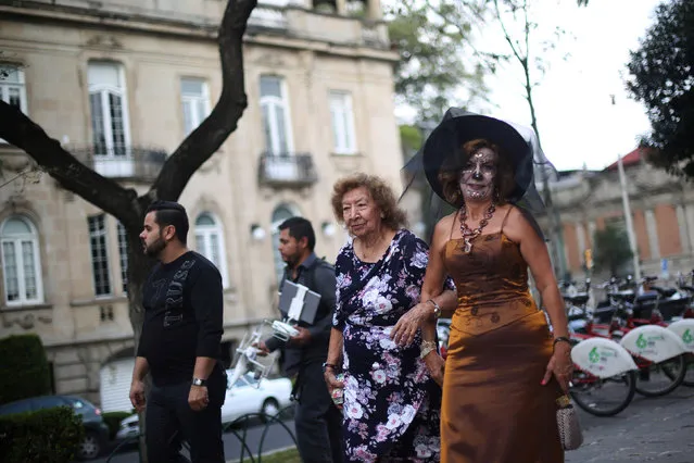 A woman with her face painted as popular Mexican figure “Catrina” walks after the annual Catrina Fest,  as part of Day of the Dead celebrations, in Mexico City, Mexico, November 2, 2016. (Photo by Edgard Garrido/Reuters)
