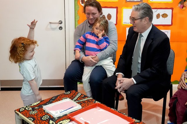 Britain's Prime Minister Keir Starmer (R) speaks to three-year-old Amelie during his visit to a nursery in central London December 1, 2025, ahead of his post-Budget speech, where he is expected to signal a fresh push on welfare reform and highlight the scrapping of the two-child limit. (Photo by Gareth Fuller/AFP Photo)