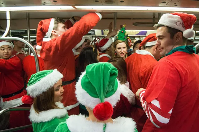 People dressed as Santas board a crowded subway during the annual SantaCon pub crawl December 12, 2015 in the Brooklyn borough of New York City. (Photo by Stephanie Keith/Getty Images)