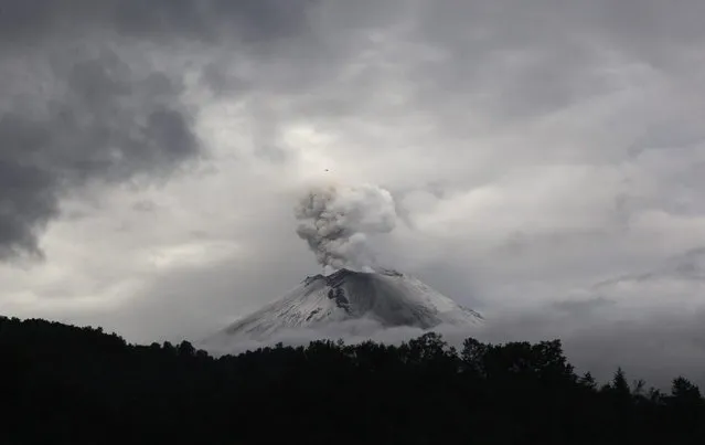 A plume of ash and steam rises from the Popocatepetl volcano as seen from the town of Santiago Xalizintla, Mexico, Sunday, July 7, 2013. Just east of Mexico City, the volcano has spit out a cloud of ash and vapor 2 miles (3 kilometers) high over several days of eruptions. Mexico's National Center for Disaster Prevention raised the volcano alert from Stage 2 Yellow to Stage 3 Yellow, the final step before a Red alert, when possible evacuations could be ordered. (Photo by Marco Ugarte/AP Photo)