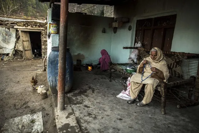 A woman adjusts her prayer beads while her daughter-in-law cooks at her house on Margalla Hills in Islamabad January 22, 2015. (Photo by Zohra Bensemra/Reuters)