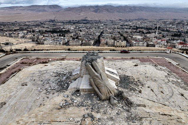 This aerial view shows the remains of a destroyed monument to Syria's late president Hafez al-Assad, father of ousted president Bashar al-Assad who died in 2000, in Deir Attiyah in the countryside of Damascus on December 28, 2024. The monument in Deir Attiyah was the largest statue of Hafez al-Assad until it was destroyed on December 8 after Bashar al-Assad fled the countrty and Islamist rebels took the capital Damascus. (Photo by Omar Haj Kadour/AFP Photo)