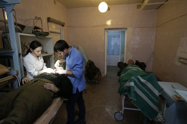 An injured Ukrainian soldier receives medical care at a hospital in the town of Artemivsk, Ukraine, Thursday, January 29, 2015. Fighting between government and Russian-backed separatist forces in eastern Ukraine has intensified in recent days as rebels seek to encircle the town of Debaltseve, which hosts a strategically important railway hub. (Photo by Petr David Josek/AP Photo)