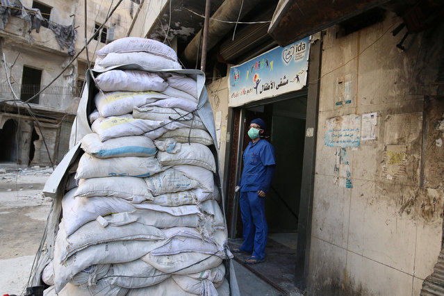 A medic stands behind sandbags in the damaged al-Hakeem hospital, in the rebel-held besieged area of Aleppo, Syria November 19, 2016. (Photo by Abdalrhman Ismail/Reuters)