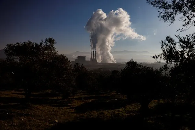 Smoke rises from Yatagan thermal power plant near southwestern town of Yatagan in Mugla province, Turkey, February 24, 2021. Five villages have already disappeared as mines serving the Yatagan power station have expanded, and the village of Turgut is now threatened. Across the province of Mugla 5,000 hectares, the equivalent of nearly 8,000 football fields, has been lost to mining in the last four decades, campaigners say. Asked about its plans to expand the mine, Yatagan Power Plant told Reuters it has planted more than 1.5 million trees in the region and its operations respect the environment and are carried out under supervision of relevant Turkish ministries. (Photo by Umit Bektas/Reuters)