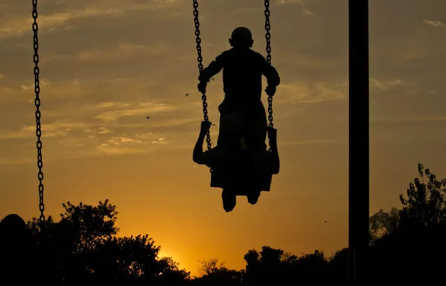 Pakistani religious students share a swing as the sun sets during a break before evening prayers at a park adjacent to their seminary in Islamabad, Pakistan, Thursday, November 26, 2015. (Photo by B.K. Bangash/AP Photo)