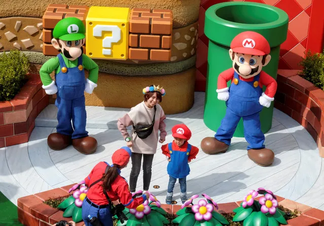 Mario and Luigi characters greet visitors in front of Yoshi's Adventure attraction inside Super Nintendo World, a new attraction area featuring the popular video game character Mario which is set to open to public on March 18, during a press preview at the Universal Studios Japan theme park in Osaka, western Japan, March 17, 2021. (Photo by Irene Wang/Reuters)
