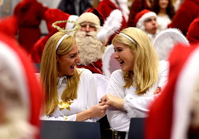 Students dressed as Santa Claus and as angels attend the general meeting of Berlin's Santas and angels in Berlin, Germany, Saturday, November 26, 2016. Students and others are introduced at the meeting how to handle their jobs in the German capital during this year's Christmas season. (Photo by Rainer Jensen/DPA via AP Photo)