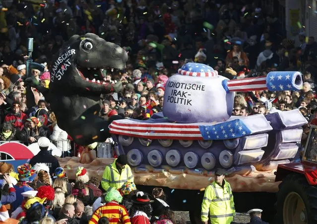 A carnival float with a papier-mache caricature drives past revellers during the traditional Rose Monday carnival parade in the western German city of Duesseldorf February 16, 2015. (Photo by Ina Fassbender/Reuters)