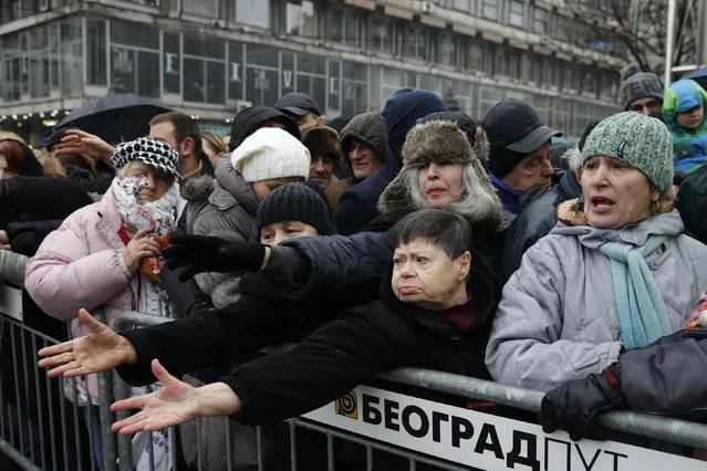 People gather to receive a piece of traditional Christmas bread, marking the Orthodox Christmas Day festivities in Belgrade, Serbia January 7, 2016. (Photo by Marko Djurica/Reuters)