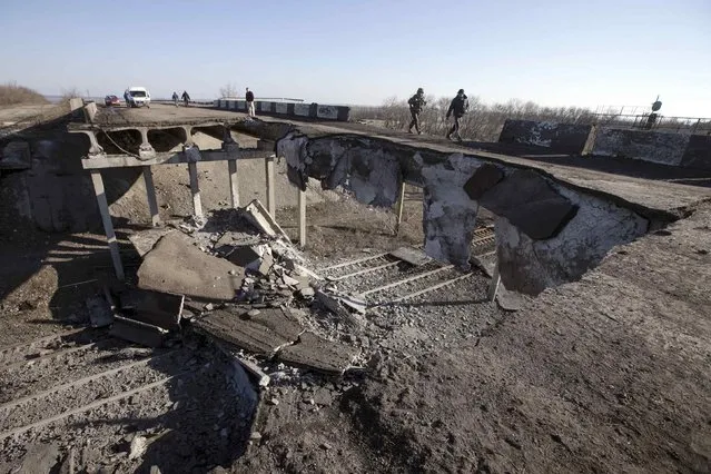 Fighters with the separatist self-proclaimed Donetsk People's Republic army walk over a partially destroyed bridge in the town of Debaltseve February 22, 2015. Pro-Moscow rebels said they would start to withdraw heavy weapons from the front line in eastern Ukraine on Sunday but the government in Kiev said armoured columns had crossed the border from Russia to reinforce the separatists.   
REUTERS/Baz Ratner(UKRAINE - Tags: POLITICS CIVIL UNREST CONFLICT MILITARY)