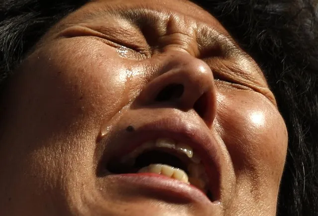 Liu Guiqiu, whose son was onboard the missing Malaysia Airlines flight MH370, cries during a gathering of family members of the missing passengers outside the Malaysian embassy in Beijing March 8, 2015. Malaysian and Chinese officials say they are committed to the search for MH370 and in assisting families who are still waiting for concrete information on what happened to their loved ones a year ago. REUTERS/Kim Kyung-Hoon