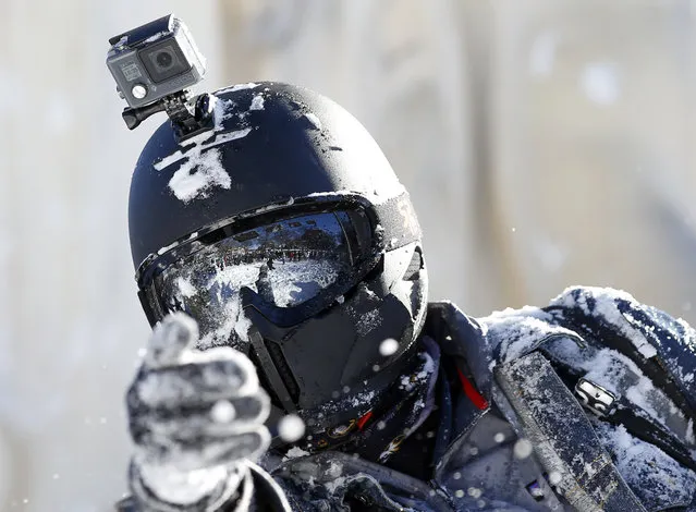 A man tosses a snowball while wearing a full helmet and GoPro, during an organized snowball fight at Dupont Circle Sunday, January 24, 2016 in Washington. (Photo by Alex Brandon/AP Photo)