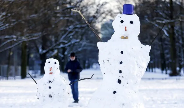 A man passes two snowmen at the Tiergarten park in Berlin, Germany, January 18, 2016. (Photo by Hannibal Hanschke/Reuters)