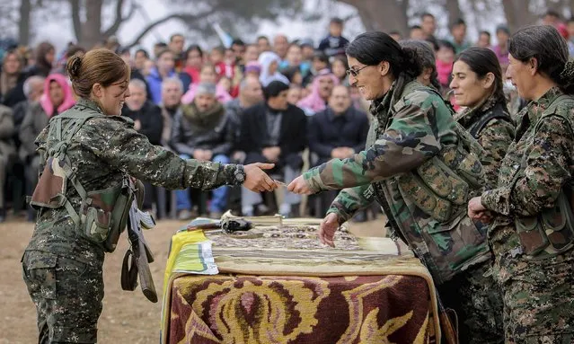 A female fighter of the Kurdish People's Protection Units (YPG) receives a military card at a military camp in Ras a-Ain, January 30, 2015. (Photo by Rodi Said/Reuters)