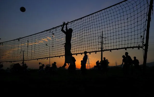 Laborers play volleyball as the sun sets in a slum area on the outskirts of Islamabad, Pakistan, Monday, July 5, 2021. (Photo by Anjum Naveed/AP Photo)