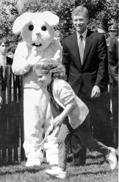 April 1, 1991 U.S. Vice President Dan Quayle (R) accompanied by giant bunny watch the Easter Egg Poll on the south grounds of the White house 1 April annual event held the Monday after Easter attracts thousands of area children. (Photo by J. David Ake/AFP Photo)