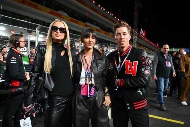 US snowboarder Shaun White (R), Canadian actress Nina Dobrev (C) and US media personality and businesswoman Paris Hilton (L) tour the grid before the start of the Las Vegas Formula One Grand Prix on November 18, 2023, in Las Vegas, Nevada. (Photo by Angela Weiss/AFP Photo)