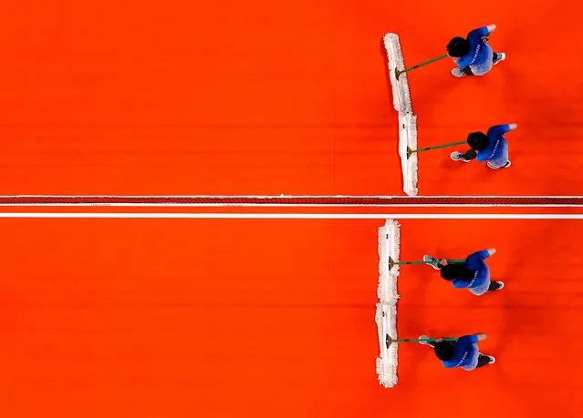 Staff members clean the court during the Women's Preliminary Round - Pool B volleyball match between China and Argentina on day ten of the Tokyo 2020 Olympic Games at Ariake Arena on August 2, 2021 in Tokyo, Japan. (Photo by Carlos Garcia Rawlins/Reuters)