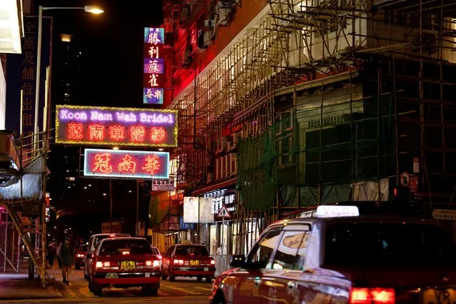 Taxis drive under neon and LED signs at Yau Ma Tei, in Hong Kong, China on August 8, 2021. (Photo by Tyrone Siu/Reuters)