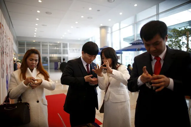 Couple measure their fingers for wedding rings after an opening ceremony for an upcoming mass wedding ceremony of the Unification Church at Cheongshim Peace World Centre in Gapyeong, South Korea, February 19, 2016. (Photo by Kim Hong-Ji/Reuters)