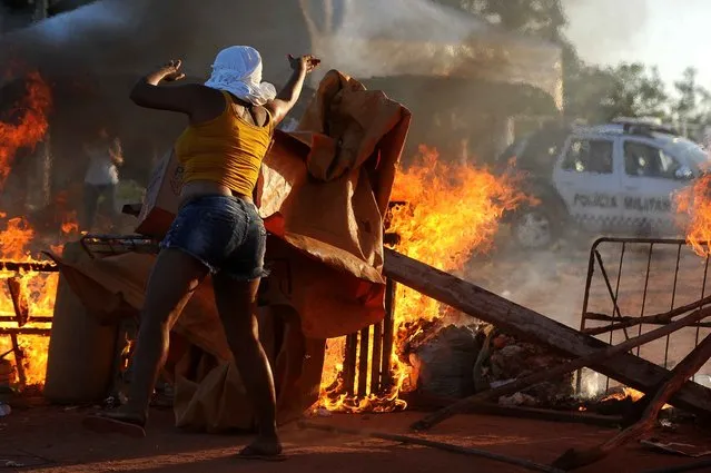 Women relatives of inmates set makeshift barricades on fire in protest for the transfer of some 200 prisoners from the Alcacuz Penitentiary Center to other prisons in Rio Grande do Norte, Brazil on January 18, 2017 Brazilian authorities said Wednesday they are deploying 1,000 troops to “clean out” arms and cellphones from restive prisons while police moved to end a deadly gang face- off in one northern penitentiary. (Photo by Andressa Anholete/AFP Photo)