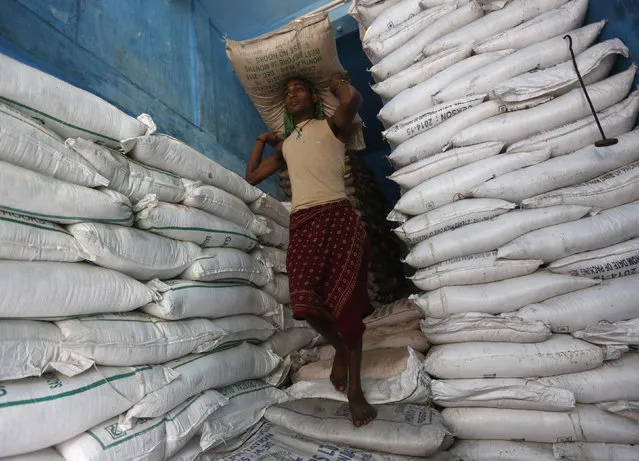 A labourer carries a sack filled with sugar in a store at a wholesale market in Kolkata, India, February 15, 2016. India's wholesale prices fell for a 15th straight month in January, declining an annual 0.90 percent, driven down by tumbling oil prices, government data showed on Monday. (Photo by Rupak De Chowdhuri/Reuters)