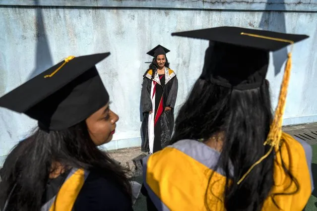 Students take selfies after their convocation ceremony of the Tribhuvan University, in Kathmandu, Nepal, Monday, December 18, 2023. The constitution of Nepal has mandated the provision of free and compulsory basic and secondary education. (Photo by Niranjan Shrestha/AP Photo)