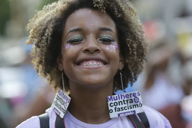 A woman wears earrings that read in Portuguese “Women against fascism” during a march marking International Women's Day in Rio de Janeiro, Brazil, Friday, March 8, 2019. (Photo by Silvia Izquierdo/AP Photo)