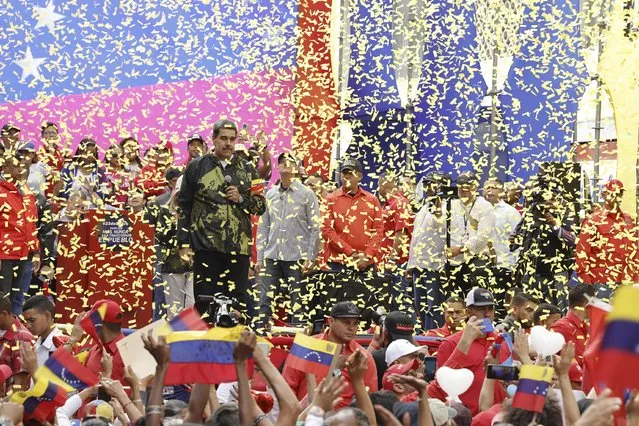Confetti showers the stage as Venezuela's President Nicolas Maduro speaks during an event marking the anniversary of the 1958 coup that overthrew dictator Marcos Perez Jimenez, in Caracas, Venezuela, January 23, 2024. (Photo by Jesus Vargas/AP Photo)