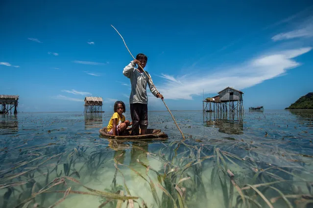 The Bajau people of Malaysia live their lives completely at sea, living in wooden huts and spending their days fishing. Sailing over crystal clear waters, the Bajau people of Malaysia live their lives almost entirely at sea. Children as young as four catch fish, octopus and lobsters from handmade boats off the eastern coast of Sabah, Malaysia. (Photo by Ng Choo Kia/Hotspot Media/SIPA Press)