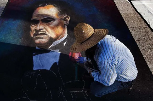 Manuel Gomez, of West Palm Beach, works on a painting of Marlon Brando in “The Godfather”. This is the eighth year Gomez has participated in the festival. (Photo by Mark Edelson/The Palm Beach Post)