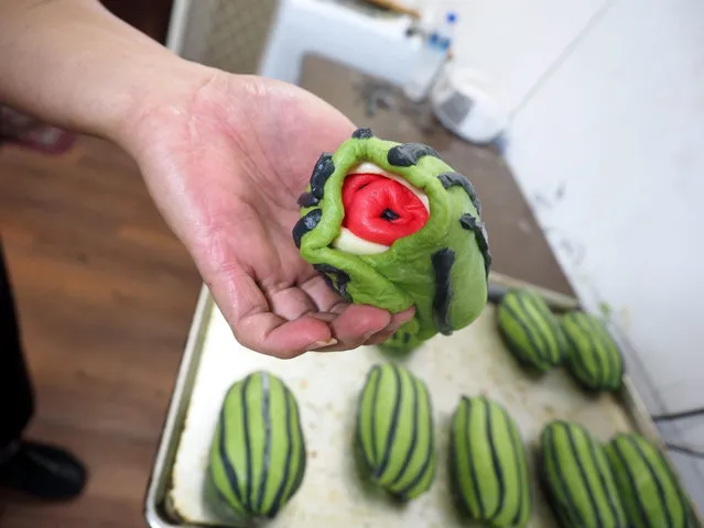 A baker shows how to make a 'watermelon toast' at the Jimmy's Bakery in Jiaohsi Township, Yilan County, northern Taiwan, 11 May 2015. Lee Wen-fa, owner of the bakery, began making “watermelon toast” in April 2015 to make toast interesting to children as kids lose their appetite in summer when the weather gets hot. (Photo by David Chang/EPA)