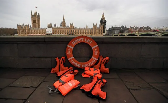 Life vests sit on the promenade along the River Thames during a “Refugees Welcome” protest in London, Britain, 07 December 2021. The Nationality and Borders Bill is being debated in parliament on 07 December. (Photo by Andy Rain/EPA/EFE)