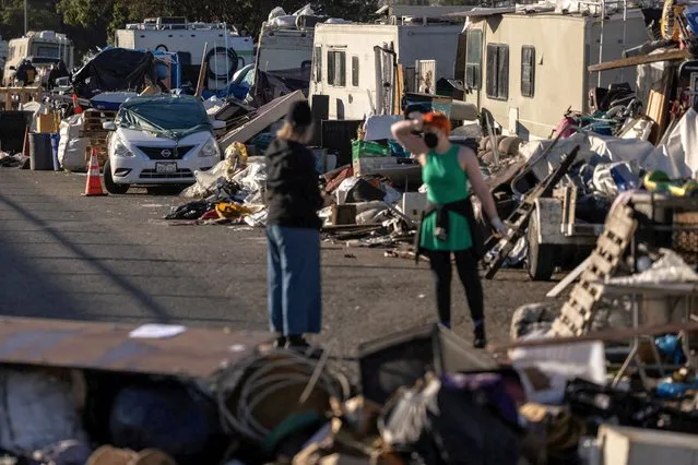 Volunteers help to clean up belongings at an encampment of homeless people near the Nimitz Freeway in Oakland after the city issued an order to remove and clean up the area where between 30 to 40 people live in cars, RVS, tents, and other makeshift structures in Oakland, California, U.S., April 2, 2024. (Photo by Carlos Barria/Reuters)
