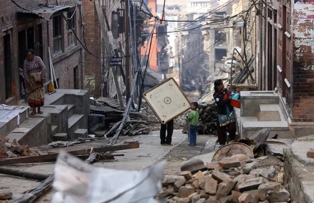A Nepalese child carries a carrom board out from his damaged house in Bhaktapur, Nepal, Thursday, May 14, 2015. (Photo by Bikram Rai/AP Photo)