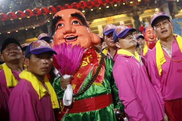 Performers stand together as they wait for the start of a nine-day procession to honour the Taoist goddess Mazu, in Taichung, Taiwan April 8, 2016. (Photo by Tyrone Siu/Reuters)