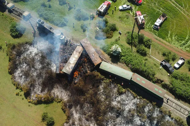 Aerial view of several freight wagons and a locomotive that were derailed and set on fire by unknown attackers in Victoria, Araucania region, Chile, on November 2, 2021. (Photo by Aton Chile/AFP Photo)