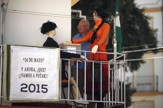 Jose Maria Leon, 73, poses for a photo next to his installation with mannequins, depicting a woman casting her vote in a polling station, on the balcony of his flat in Ronda, southern Spain, May 23, 2015. (Photo by Jon Nazca/Reuters)